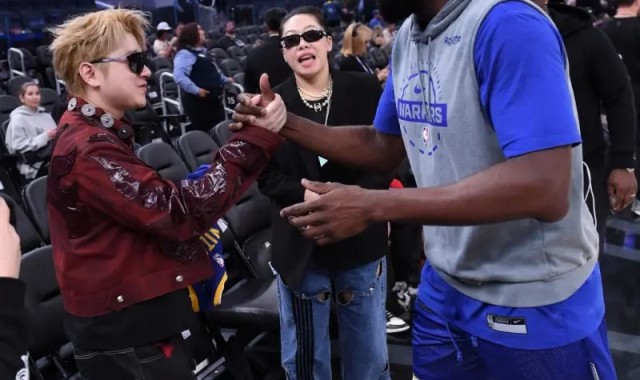 格林与王以太握手致意，并在后者的专属球衣上留下签名